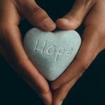 Resurrection to give us hope. 
 Holding a "Hope" sign with both hands