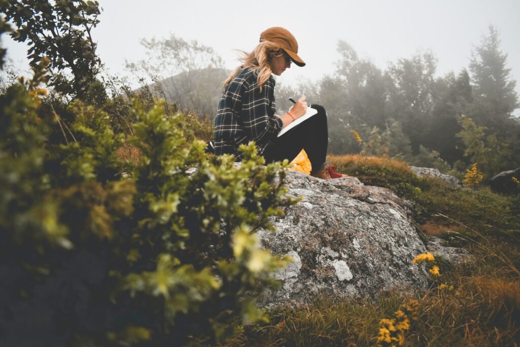 A woman sitting on a rock journaling, living in God's grace.