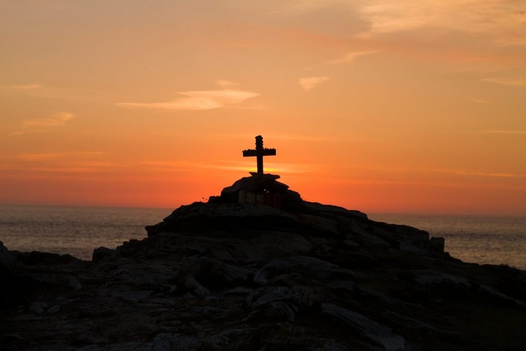 Cross on a hill at sunset. Why did Jesus have to die?