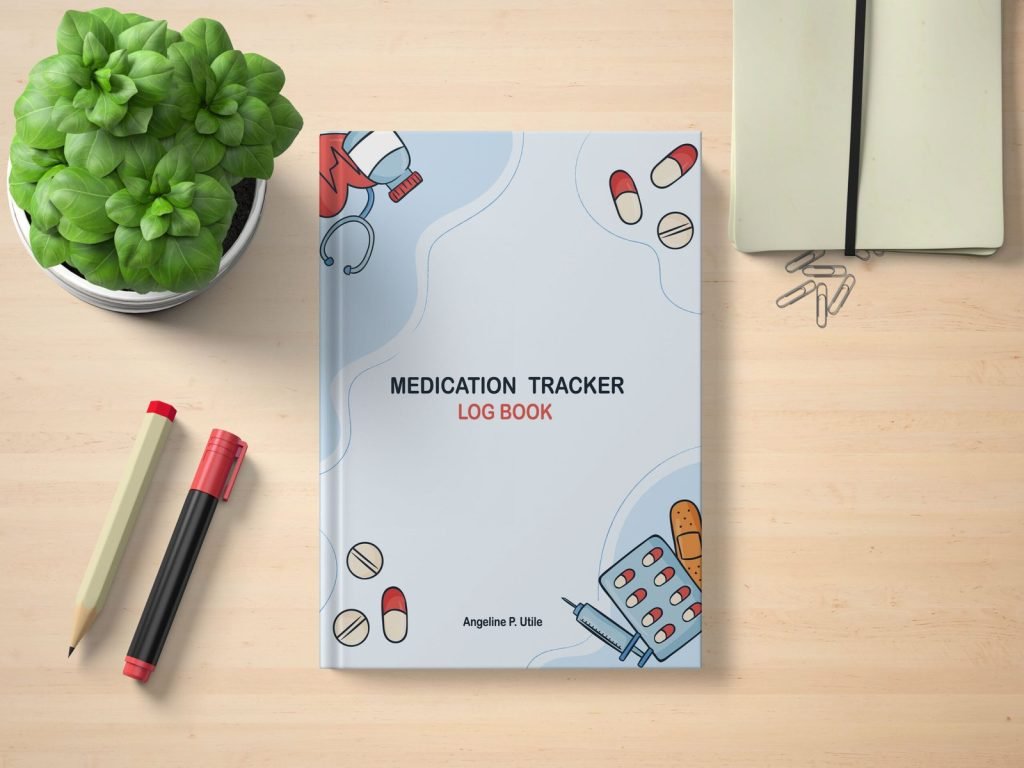 Medication Tracker Log Book by Angeline P. Utile on a wooden desk with pens, notebook, paperclips, and a potted plant — cover features medical illustrations like pills, syringe, and stethoscope